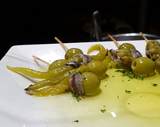 Tapas z olivy, papriky a ančovičky v barcelonském baru (Španělsko)