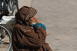 Chudý muž poblíž brány Bab Agnaou v Marrákeši (Maroko)